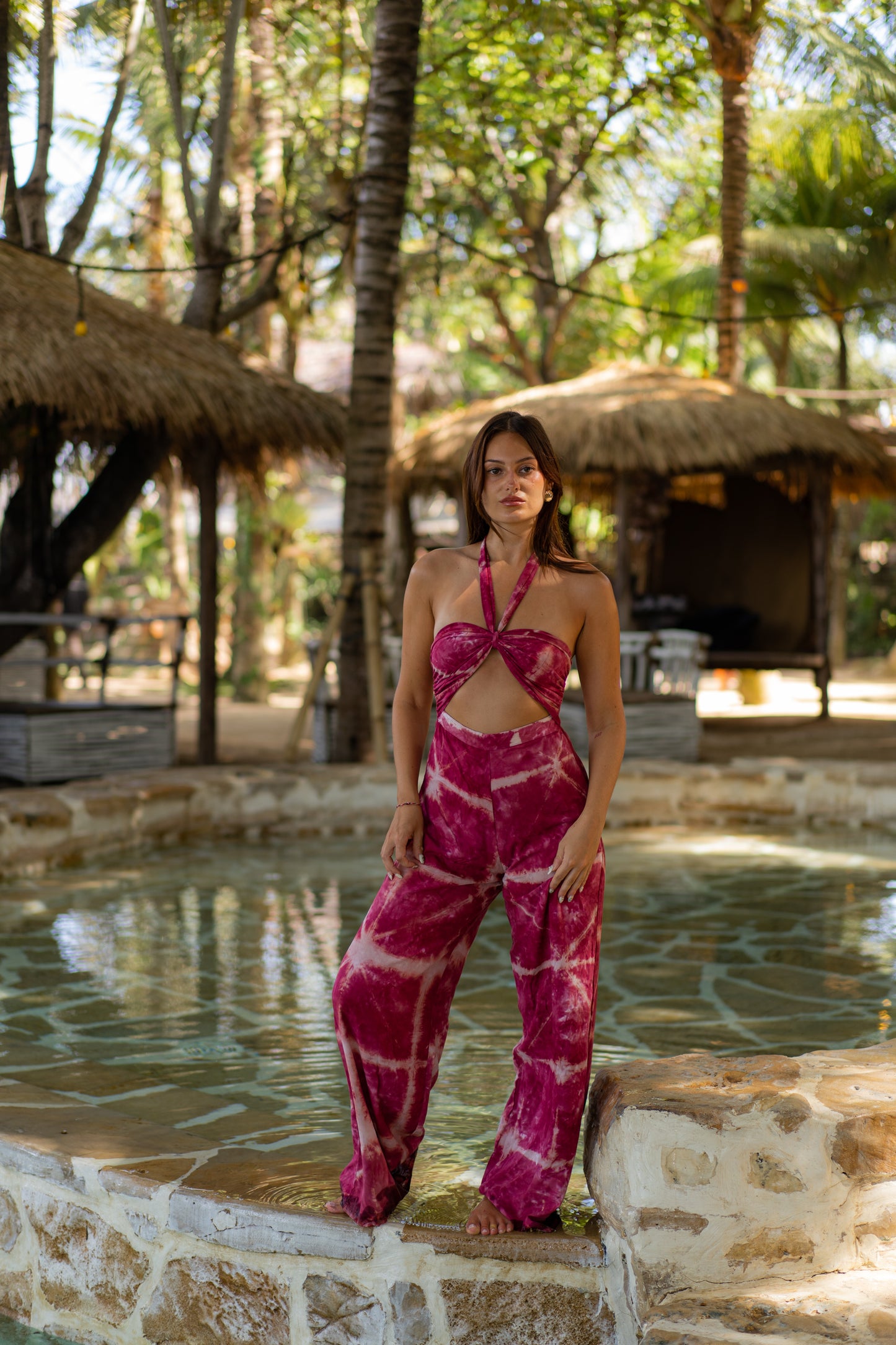 MOSS The Label sleeveless cut-out halter neck pink tie-dye jumpsuit worn outdoors