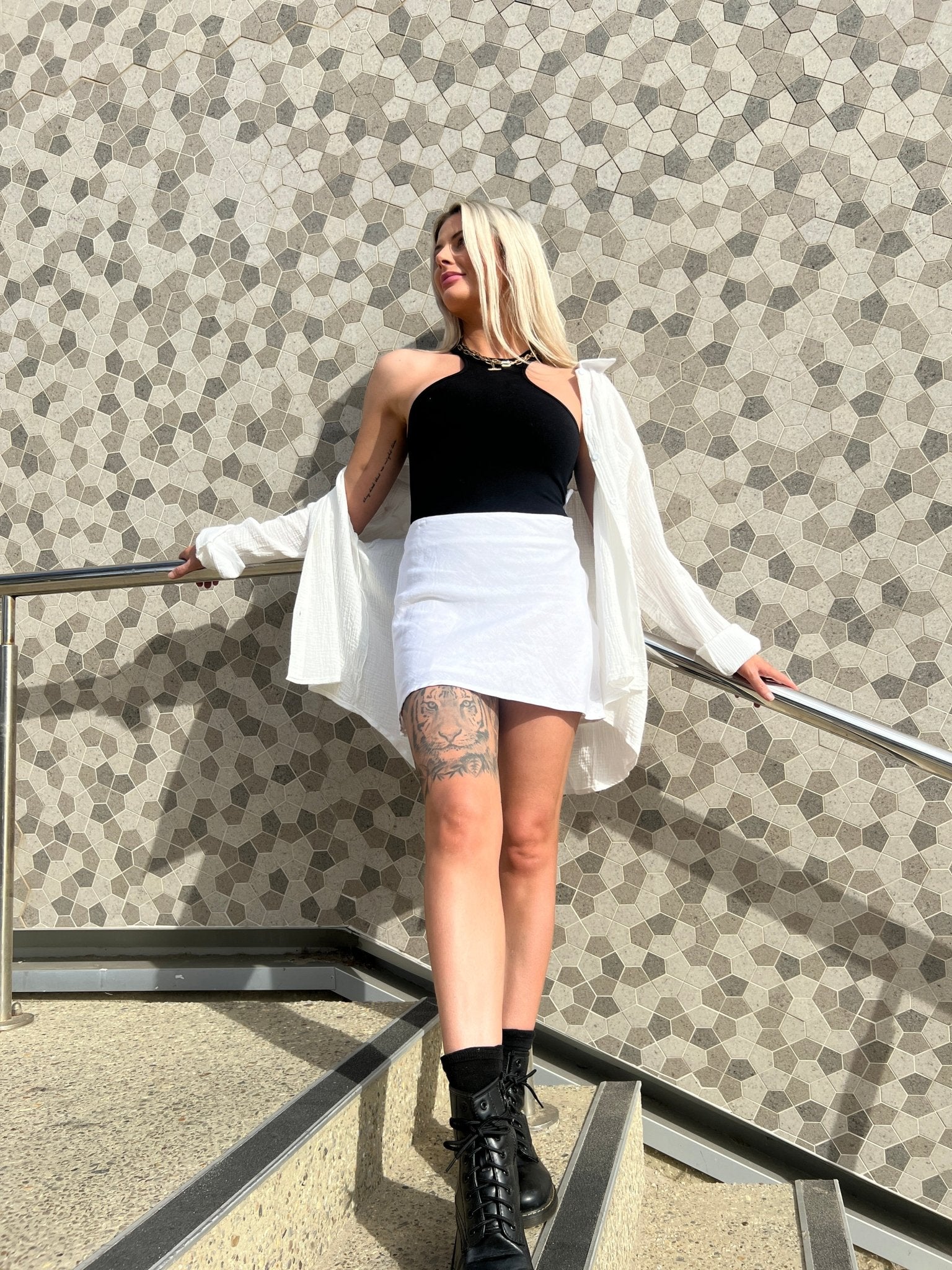 MOSS The Label black bodysuit worn with white skirt and open white shirt styled with black boots